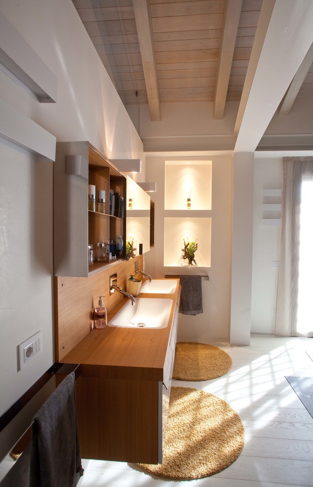 Photo of a scandinavian bathroom in Bologna with light wood cabinets, white walls, painted wood floors, a drop-in sink, wood benchtops and brown benchtops.