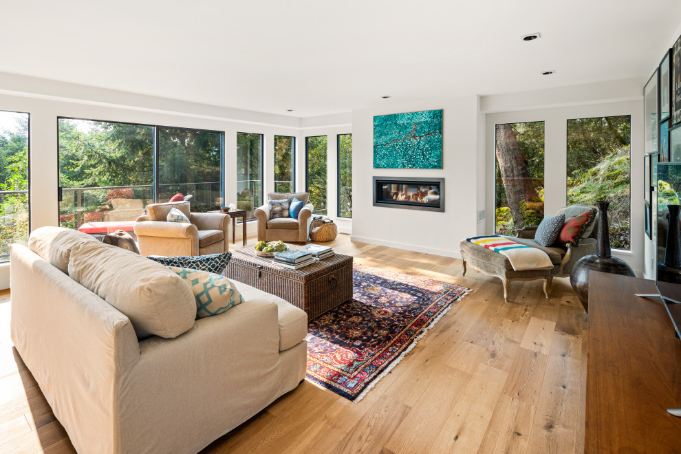 Photo of a mid-sized midcentury formal open concept living room in Vancouver with white walls, light hardwood floors, a ribbon fireplace, a freestanding tv and beige floor.