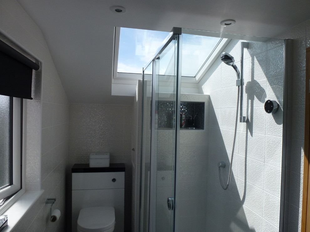 Immagine di una piccola stanza da bagno con doccia moderna con doccia ad angolo, WC monopezzo, piastrelle bianche e pareti bianche
