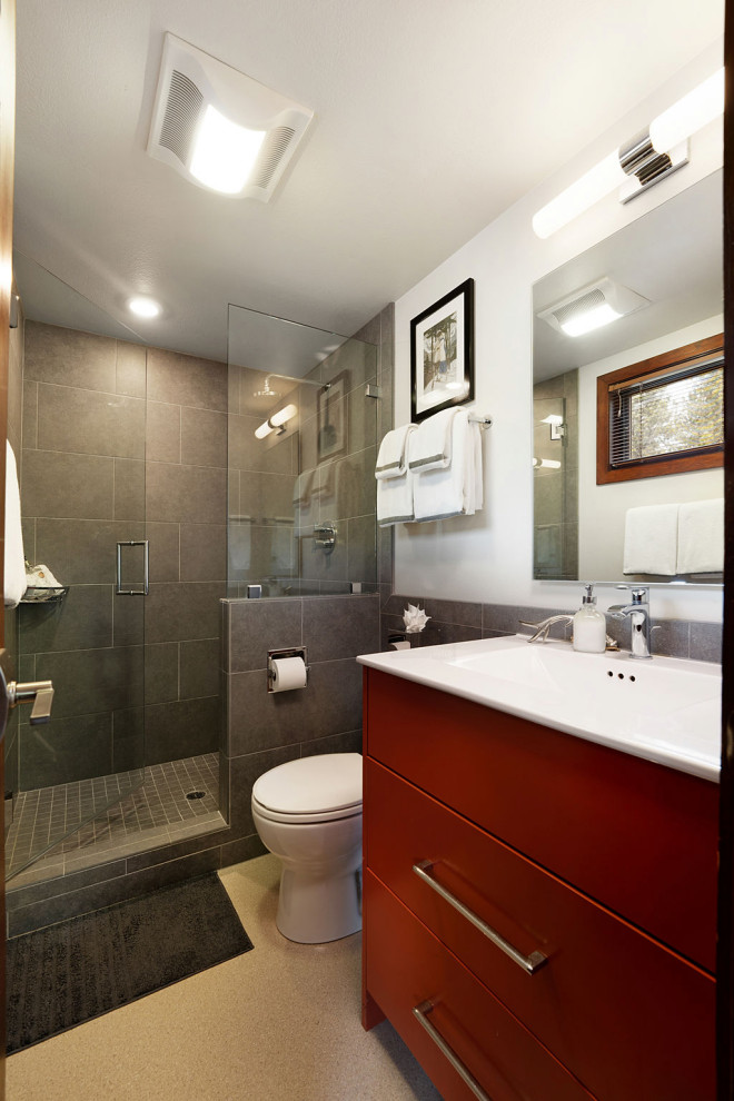 Foto på ett litet vintage vit badrum med dusch, med släta luckor, orange skåp, en dusch i en alkov, en toalettstol med hel cisternkåpa, vit kakel, porslinskakel, vita väggar, linoleumgolv, ett integrerad handfat, bänkskiva i kvartsit, beiget golv och dusch med gångjärnsdörr