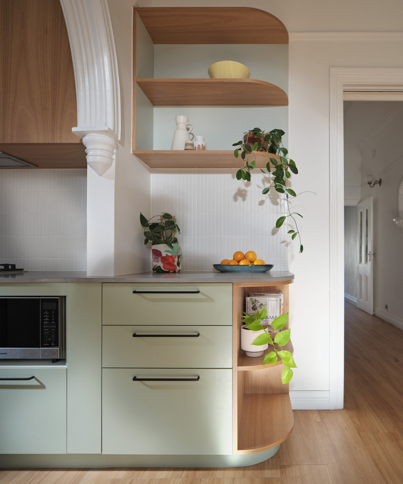 Mid-sized modern u-shaped eat-in kitchen in Sydney with an undermount sink, flat-panel cabinets, green cabinets, recycled glass benchtops, white splashback, matchstick tile splashback, stainless steel appliances, no island and grey benchtop.