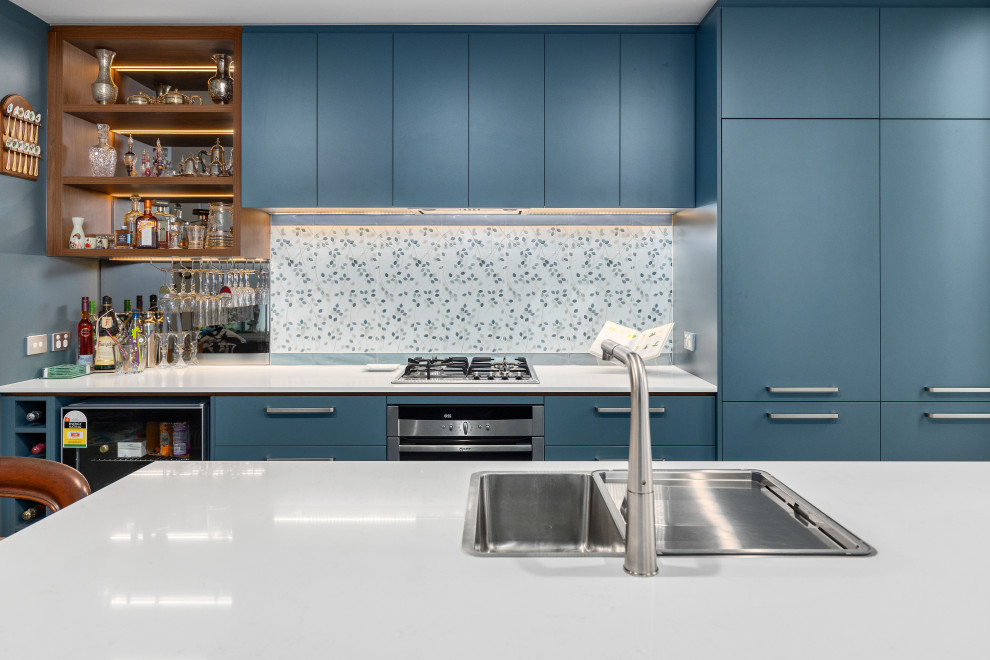 Exempel på ett stort modernt vit vitt kök, med en undermonterad diskho, släta luckor, blå skåp, bänkskiva i kvarts, blått stänkskydd, stänkskydd i porslinskakel, svarta vitvaror, klinkergolv i porslin, flera köksöar och grått golv