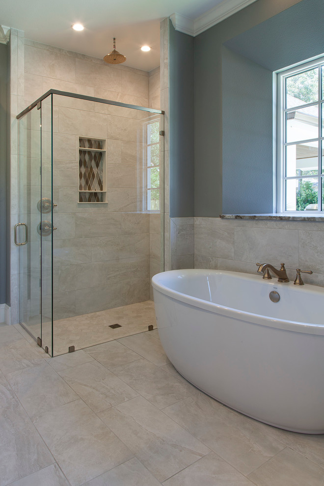 Inspiration for a large transitional master bathroom in Orlando with furniture-like cabinets, grey cabinets, a freestanding tub, a corner shower, a one-piece toilet, beige tile, grey walls, ceramic floors, an undermount sink and granite benchtops.