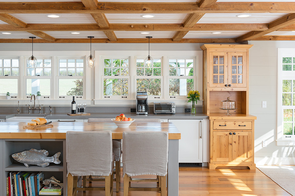 Photo of a large country kitchen in Charlotte with a farmhouse sink, shaker cabinets, medium hardwood floors, with island and wood benchtops.