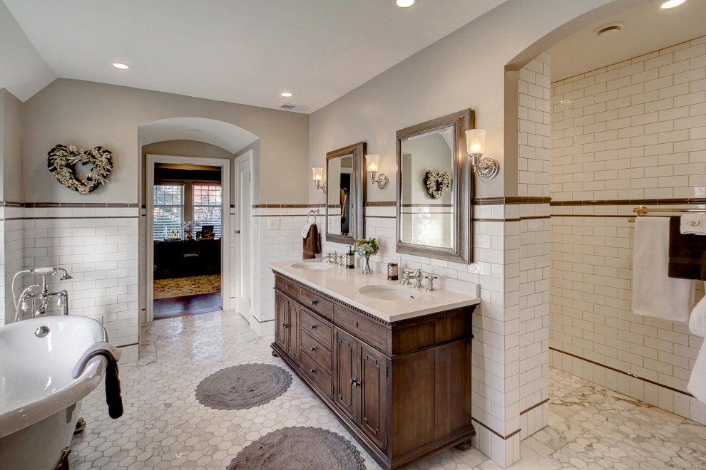 This is an example of a mid-sized traditional master bathroom in Milwaukee with beaded inset cabinets, distressed cabinets, a claw-foot tub, an open shower, a two-piece toilet, white tile, stone tile, beige walls, marble floors, a drop-in sink and engineered quartz benchtops.