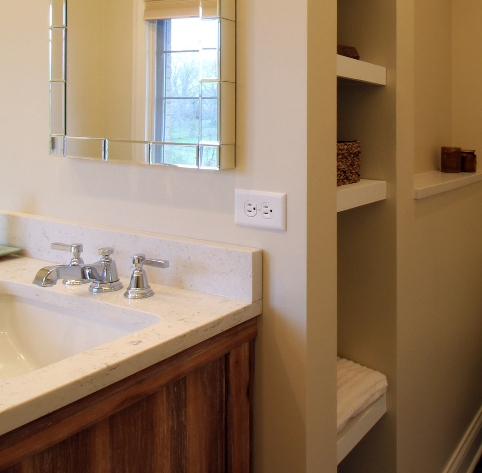 Mountain style gray tile and porcelain tile pebble tile floor doorless shower photo in Chicago with furniture-like cabinets, distressed cabinets, a one-piece toilet, beige walls, an undermount sink and quartz countertops
