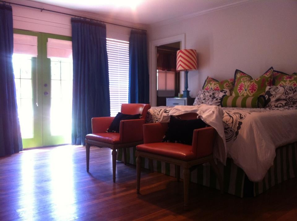 Large transitional master medium tone wood floor bedroom photo with white walls