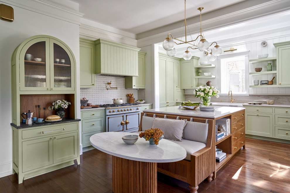 Example of a classic l-shaped dark wood floor and brown floor kitchen design in Chicago with a farmhouse sink, shaker cabinets, green cabinets, gray backsplash, stone slab backsplash, colored appliances, an island and white countertops