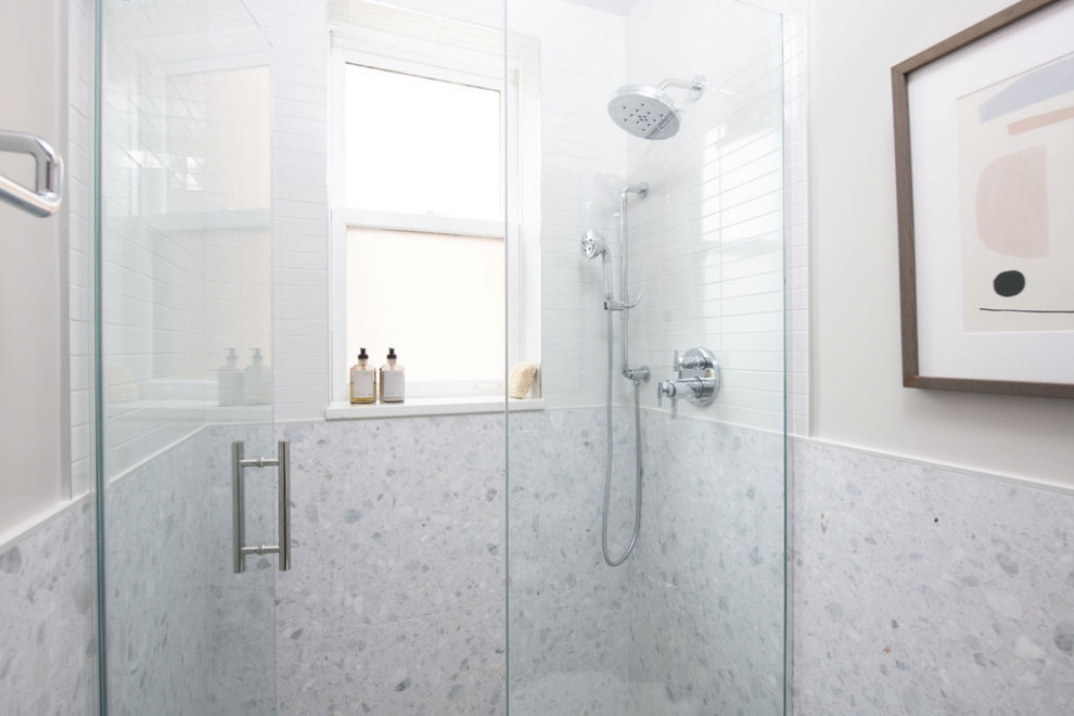 Пример оригинального дизайна: ванная комната среднего размера в стиле модернизм с плоскими фасадами, бежевыми фасадами, душем в нише, унитазом-моноблоком, разноцветной плиткой, мраморной плиткой, разноцветными стенами, полом из керамической плитки, душевой кабиной, настольной раковиной, столешницей из искусственного кварца, бежевым полом, душем с распашными дверями, белой столешницей, тумбой под одну раковину и подвесной тумбой