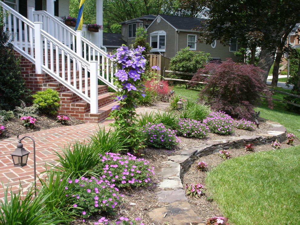 Photo of a mid-sized traditional front yard partial sun formal garden in DC Metro with brick pavers.