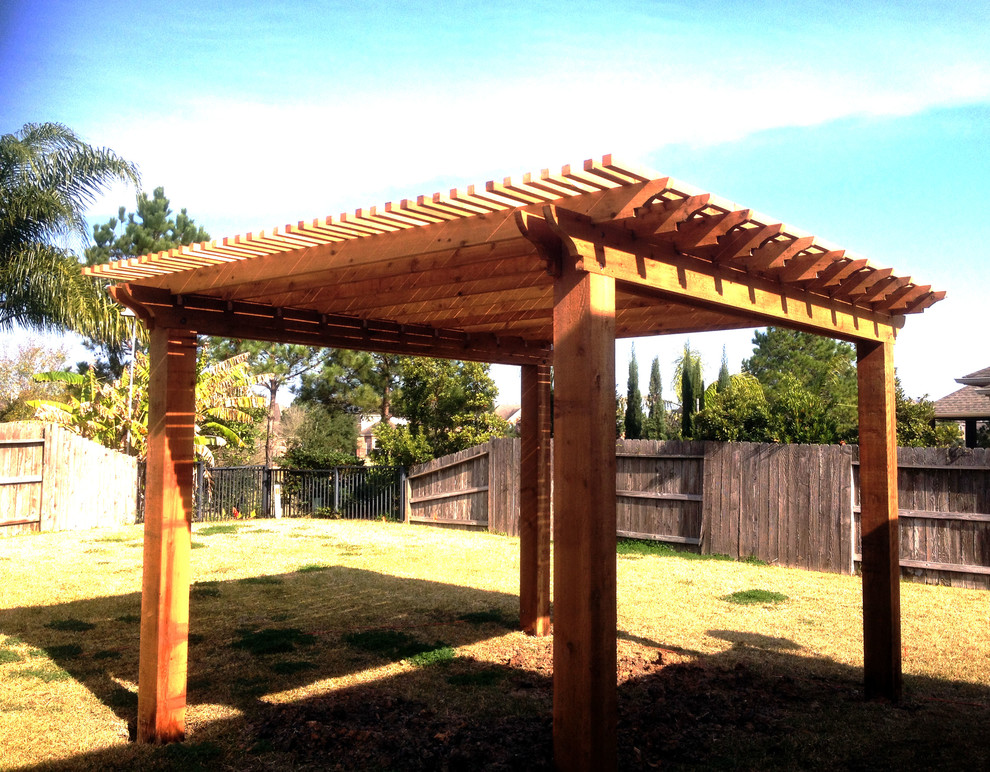 This is an example of a small traditional backyard patio in Houston with a pergola.