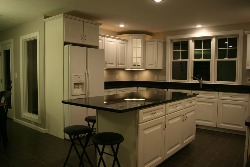 Example of a large u-shaped eat-in kitchen design with white cabinets, black backsplash and an island