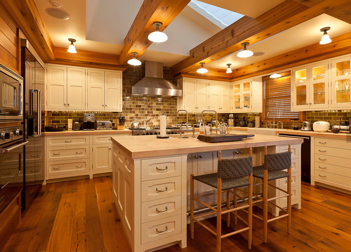 Kitchen - large rustic u-shaped medium tone wood floor and brown floor kitchen idea in Denver with a farmhouse sink, shaker cabinets, white cabinets, wood countertops, brown backsplash, brick backsplash, stainless steel appliances and an island