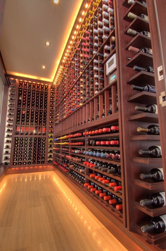 This is an example of a large contemporary wine cellar in Toronto with storage racks and porcelain floors.