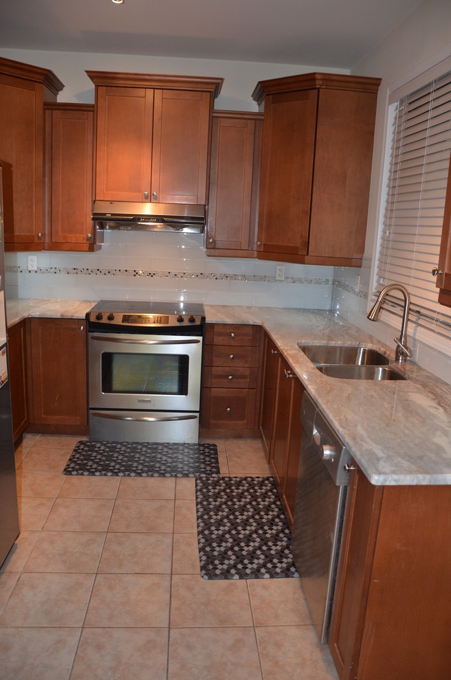 Example of a small transitional u-shaped porcelain tile home design design in Toronto with a double-bowl sink, beaded inset cabinets, medium tone wood cabinets, granite countertops, white backsplash, glass tile backsplash, stainless steel appliances and no island