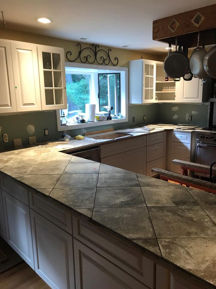 Mid-sized traditional u-shaped eat-in kitchen in Boston with a drop-in sink, shaker cabinets, white cabinets, tile benchtops, stainless steel appliances, terra-cotta floors, multiple islands, red floor and grey benchtop.