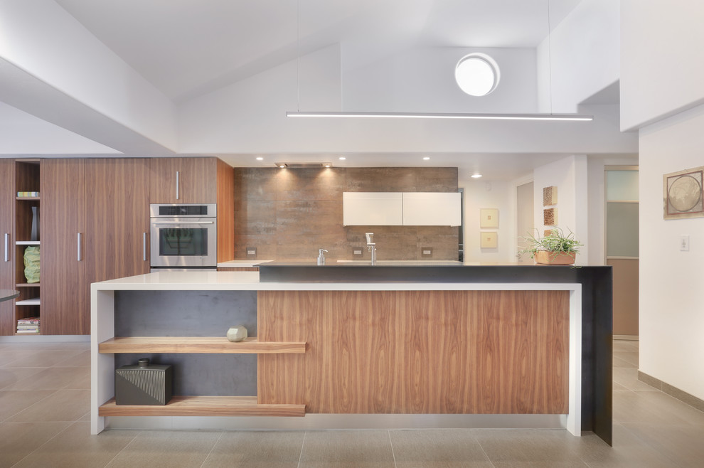Inspiration for a mid-sized modern galley porcelain tile eat-in kitchen remodel in Phoenix with an undermount sink, flat-panel cabinets, medium tone wood cabinets, quartz countertops, multicolored backsplash, ceramic backsplash, paneled appliances and an island