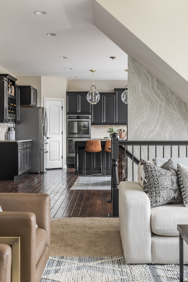 Eat-in kitchen - large transitional u-shaped dark wood floor and brown floor eat-in kitchen idea in Indianapolis with an undermount sink, beaded inset cabinets, black cabinets, beige backsplash, stone tile backsplash, stainless steel appliances, an island and gray countertops