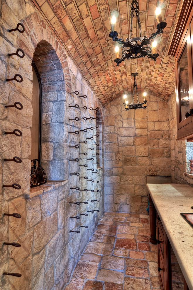 This is an example of a mediterranean wine cellar in Orange County with red floor.