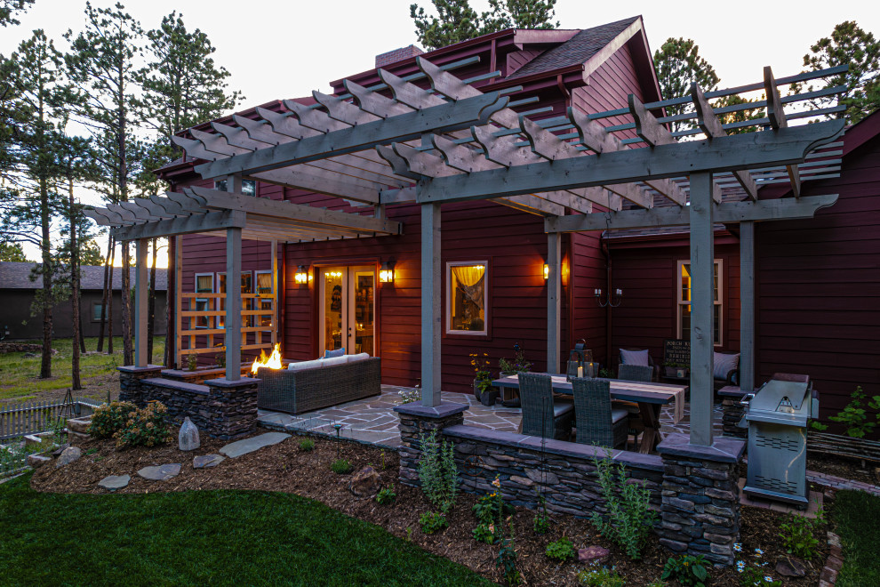 Inspiration for a mid-sized traditional backyard patio in Denver with a fire feature, natural stone pavers and a pergola.