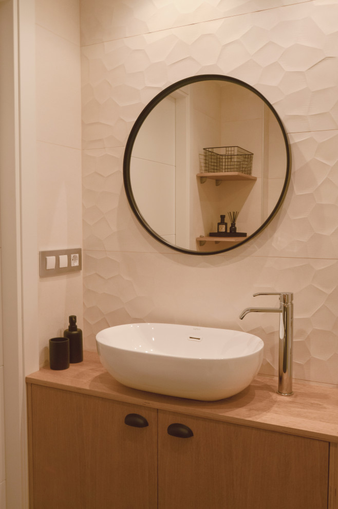 This is an example of a small contemporary 3/4 bathroom with furniture-like cabinets, medium wood cabinets, a corner shower, an urinal, beige tile, ceramic tile, beige walls, ceramic floors, a vessel sink, wood benchtops, grey floor, a sliding shower screen, brown benchtops, an enclosed toilet, a single vanity and a built-in vanity.