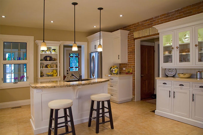 Transitional l-shaped ceramic tile kitchen photo with an undermount sink, shaker cabinets, stainless steel appliances, an island, white cabinets and granite countertops