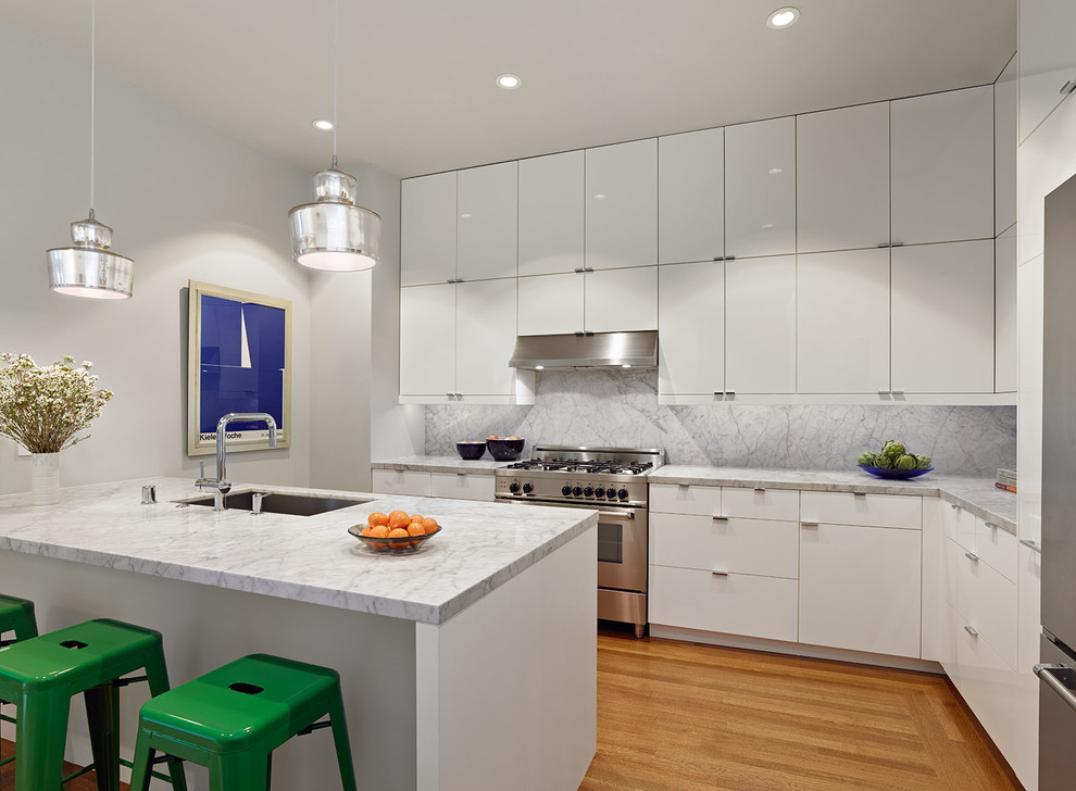 Inspiration for a contemporary kitchen in San Francisco with an undermount sink, flat-panel cabinets, white cabinets, marble benchtops, white splashback, stainless steel appliances, medium hardwood floors and a peninsula.