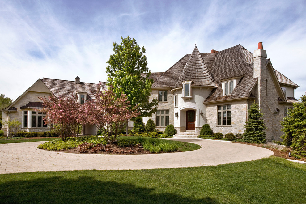 Photo of an expansive three-storey beige exterior in Chicago with stone veneer and a hip roof.