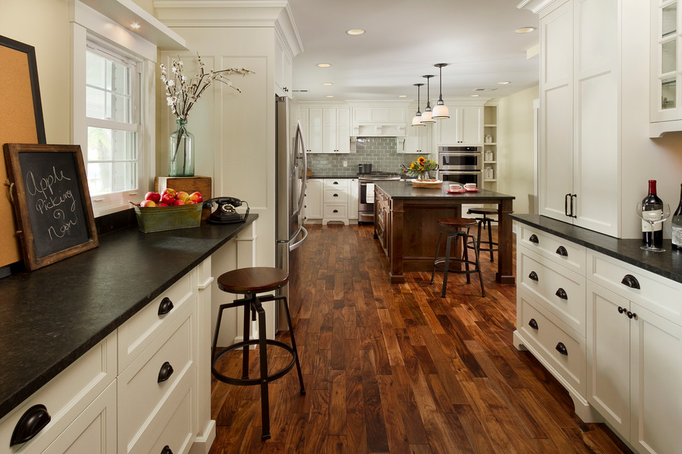 Inspiration for a large traditional l-shaped kitchen pantry in Minneapolis with an undermount sink, shaker cabinets, white cabinets, granite benchtops, blue splashback, subway tile splashback, stainless steel appliances, dark hardwood floors and with island.