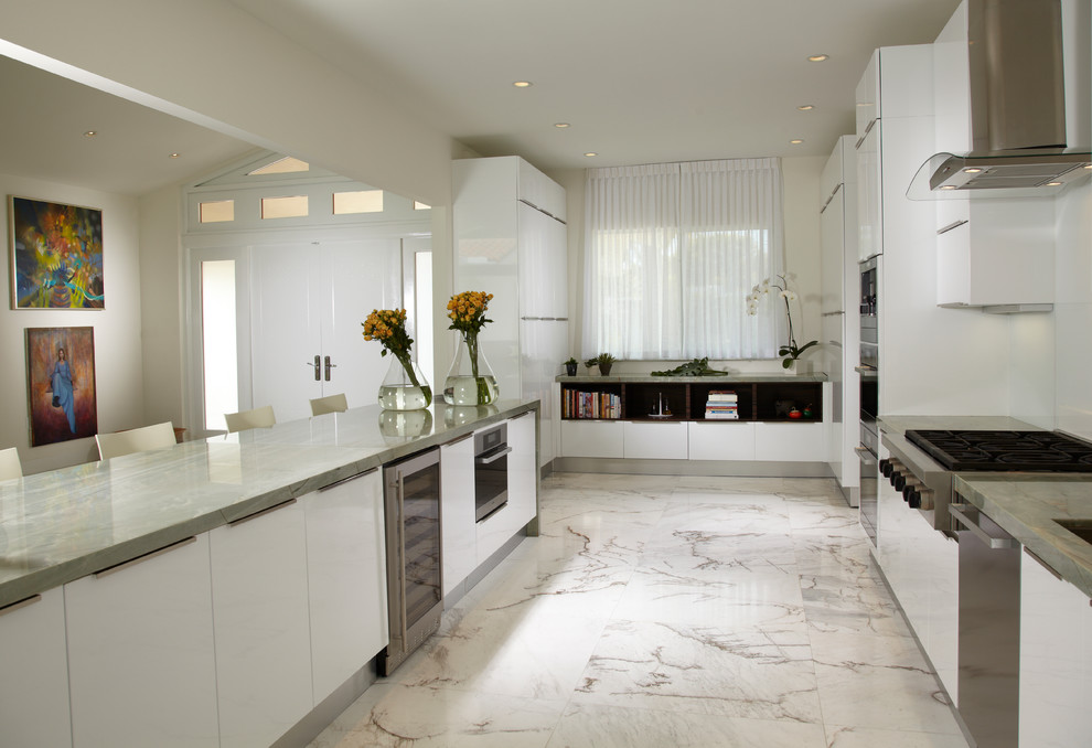 Inspiration for a mid-sized contemporary u-shaped open plan kitchen in Miami with a triple-bowl sink, white cabinets, granite benchtops, white splashback, glass sheet splashback, stainless steel appliances, marble floors and a peninsula.