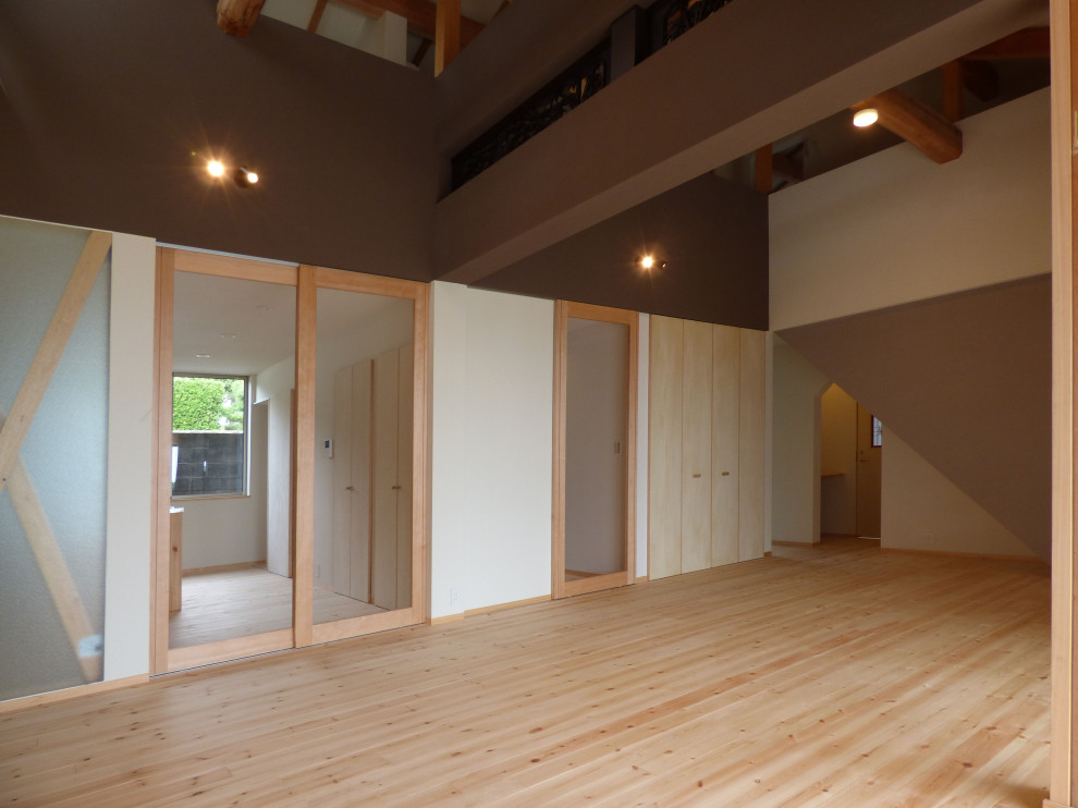 Ejemplo de salón abierto y blanco de tamaño medio con paredes blancas, suelo de madera clara, televisor independiente, vigas vistas y papel pintado