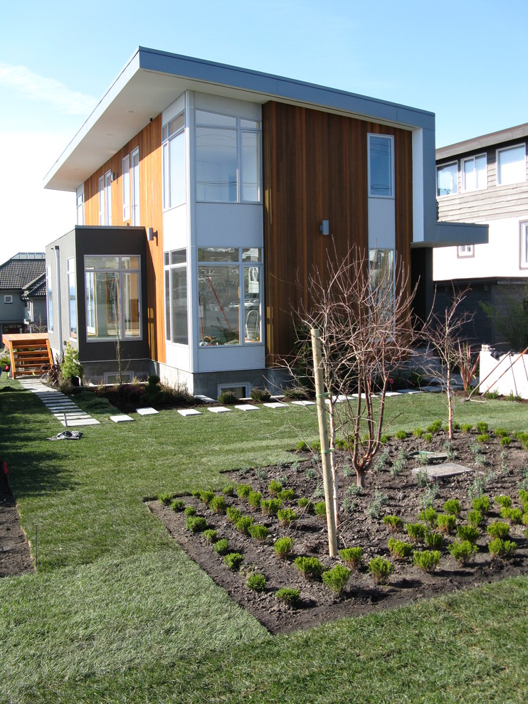 Photo of a small modern front yard full sun garden for summer in Vancouver with concrete pavers.