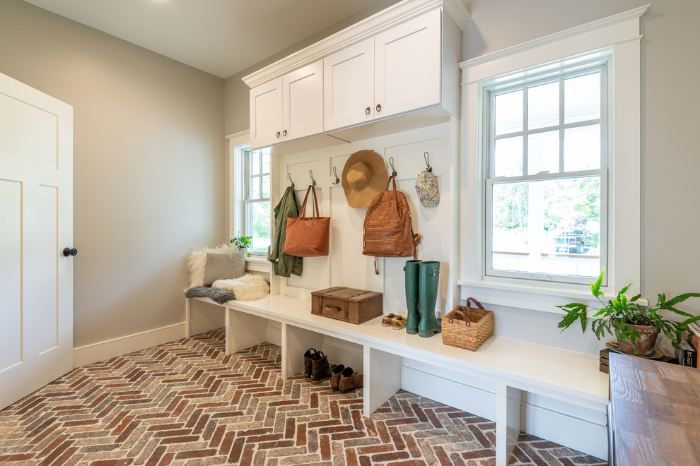 Inspiration for a mid-sized eclectic mudroom in Philadelphia with grey walls and brick floors.