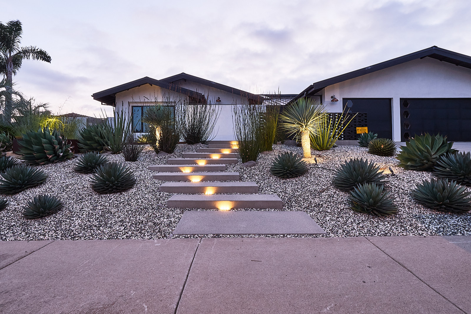 Inspiration for a mid-sized mid-century modern drought-tolerant and full sun front yard river rock landscaping in San Diego.