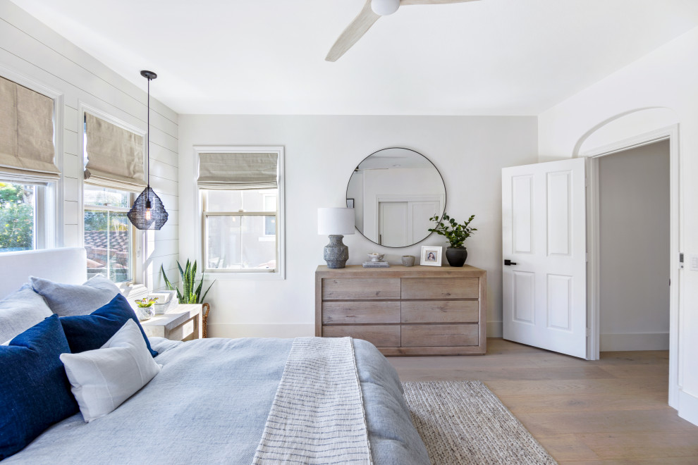 Beach style bedroom in Orange County with grey walls, medium hardwood floors and brown floor.