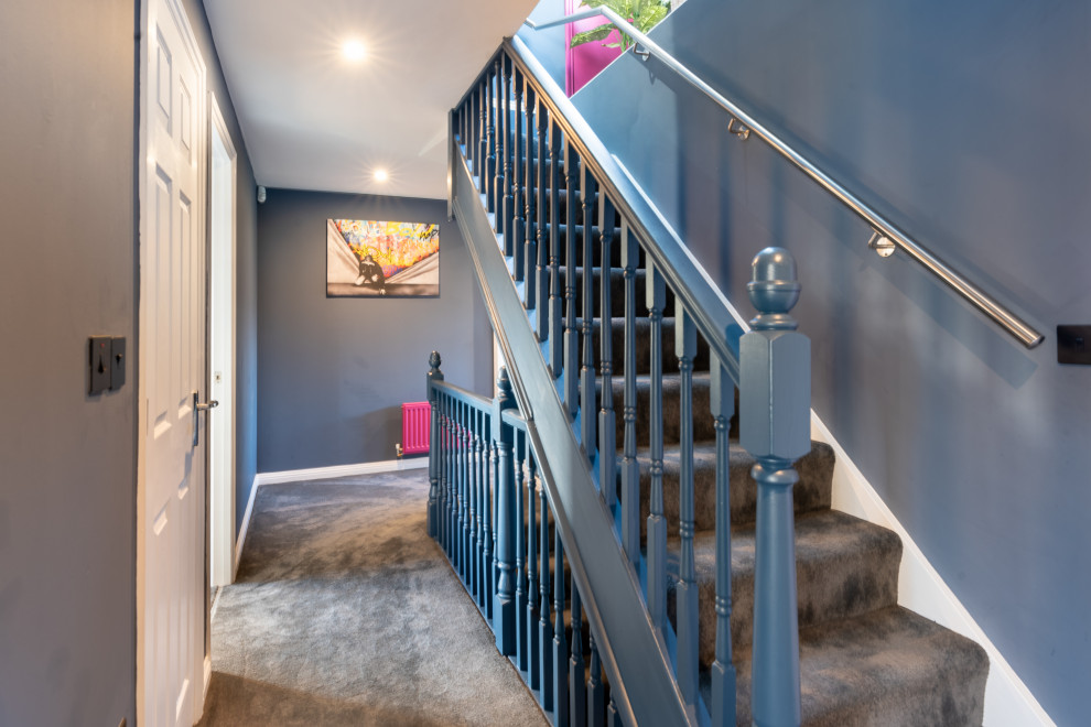 Réalisation d'un couloir design de taille moyenne avec un mur bleu, moquette et un sol gris.