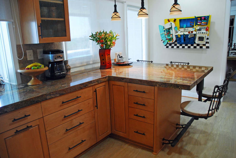 Mid-sized eclectic l-shaped eat-in kitchen in Los Angeles with flat-panel cabinets, medium wood cabinets, granite benchtops, brown splashback, vinyl floors, a peninsula, black appliances and an undermount sink.