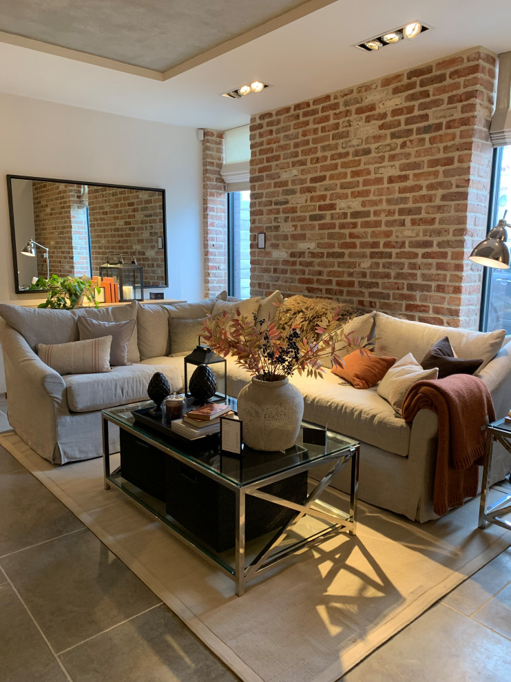 This is an example of a large transitional formal open concept living room in Sussex with white walls, ceramic floors, no fireplace, no tv and grey floor.