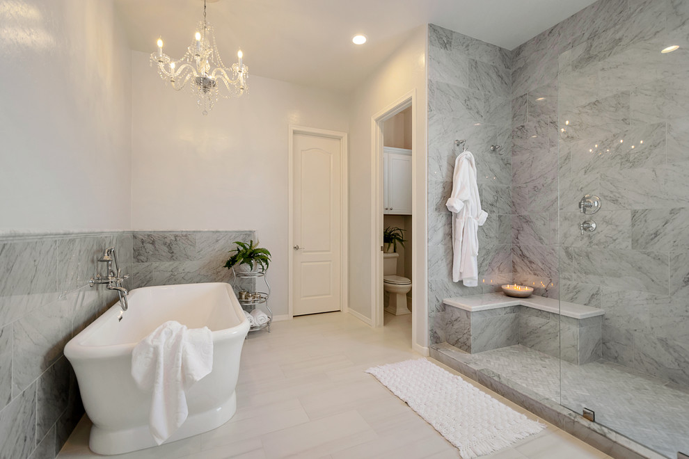 Example of a large transitional master gray tile and marble tile porcelain tile and gray floor freestanding bathtub design in Phoenix with recessed-panel cabinets, white cabinets, gray walls, a drop-in sink, quartz countertops and white countertops