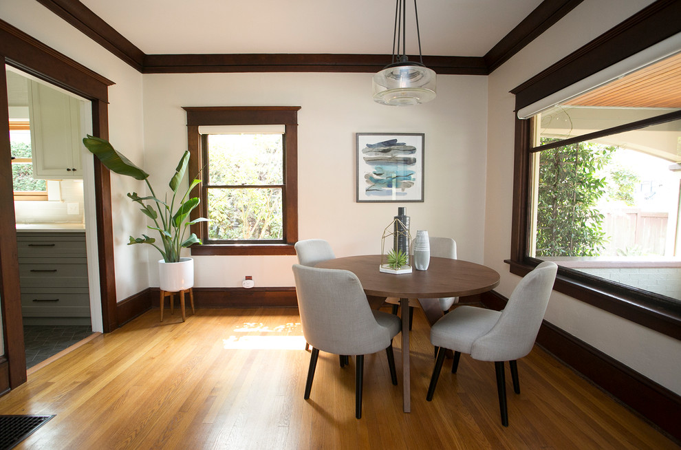 Small modern dining room in Portland with medium hardwood floors, a standard fireplace and a tile fireplace surround.