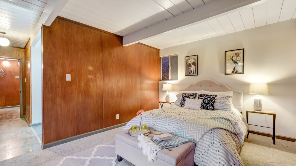 Design ideas for a midcentury bedroom in Austin with carpet, exposed beam and wood walls.