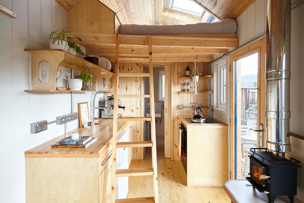 Bild på ett litet nordiskt separat vardagsrum, med grå väggar, plywoodgolv och en öppen vedspis