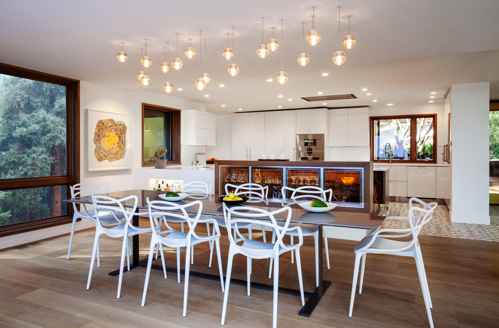 This is an example of a large midcentury open plan dining in San Francisco with white walls, medium hardwood floors, no fireplace and brown floor.