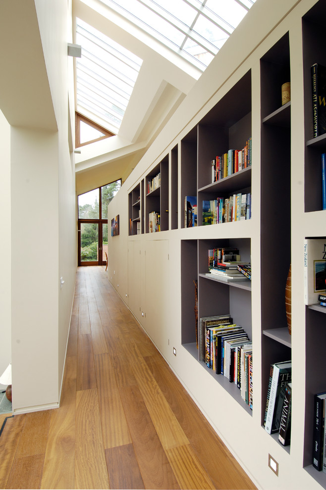 Large contemporary hallway in Sussex with white walls and dark hardwood floors.
