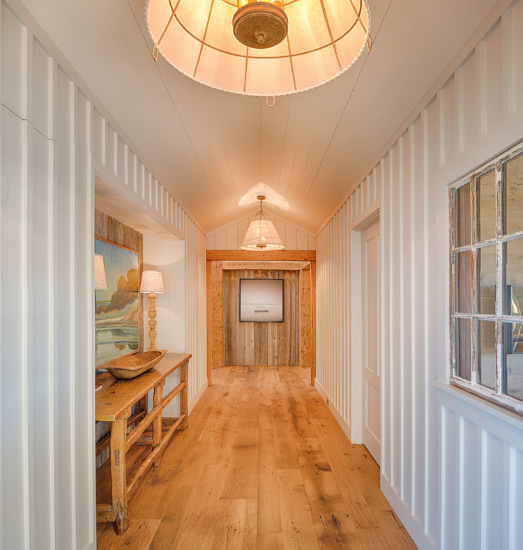 Inspiration for a large country hallway in Boston with white walls, light hardwood floors and brown floor.