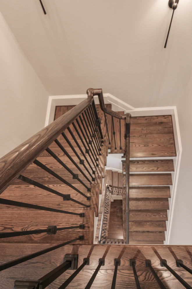 This is an example of a large traditional wood floating metal railing staircase in DC Metro with painted wood risers.