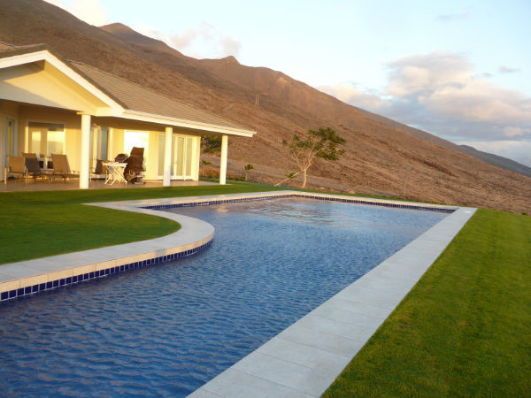 Example of a large backyard concrete paver and l-shaped lap water slide design