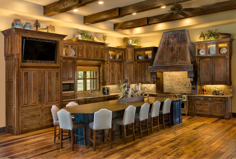 Mid-sized mountain style l-shaped medium tone wood floor and brown floor eat-in kitchen photo with an undermount sink, raised-panel cabinets, dark wood cabinets, beige backsplash, stone tile backsplash, paneled appliances, an island, granite countertops and beige countertops