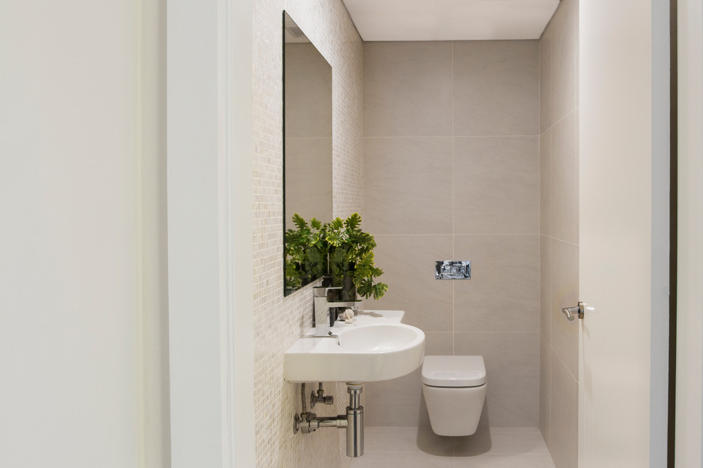 Inspiration for a small contemporary powder room in Sydney with flat-panel cabinets, mosaic tile, ceramic floors, a wall-mount toilet, beige tile, beige walls, a wall-mount sink and beige floor.