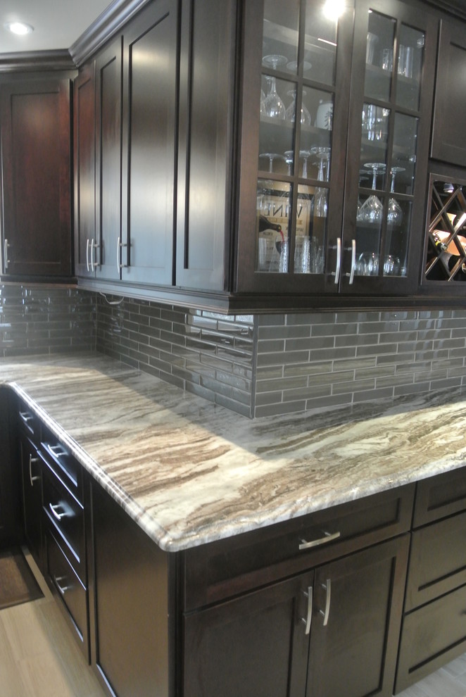 Example of a mid-sized transitional u-shaped eat-in kitchen design in Toronto with an undermount sink, shaker cabinets, dark wood cabinets, quartzite countertops, stainless steel appliances and an island